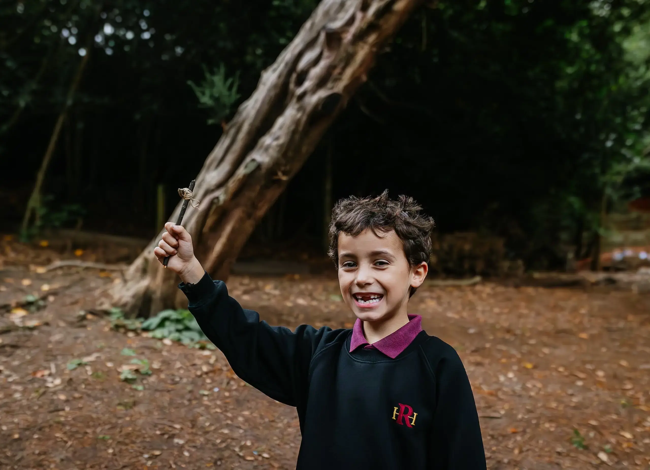 Smiling student holding up stick